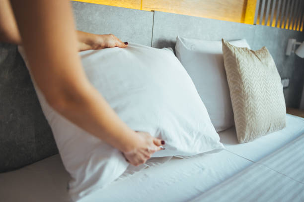 istock Female hands corrected pillow on the bed. 1366029015