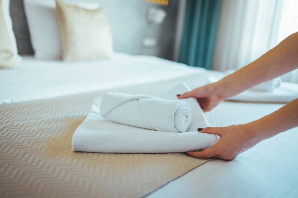 istock Female Hand set up white bed sheet in bedroom. 1366029016