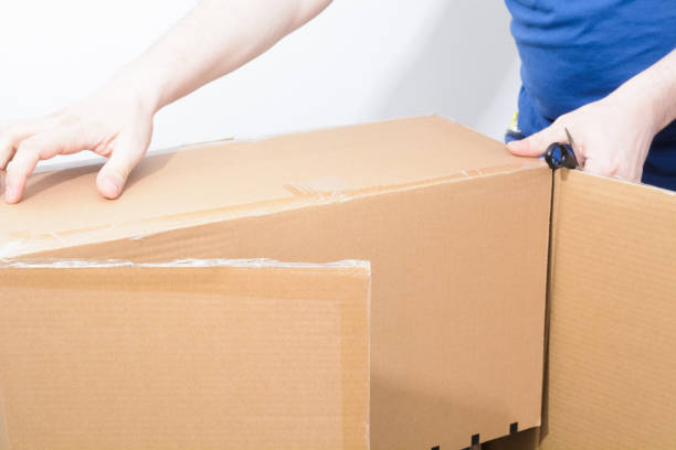 istock Caucasian man holding sharp steel box cutter knife with open cardboard box 1366030217