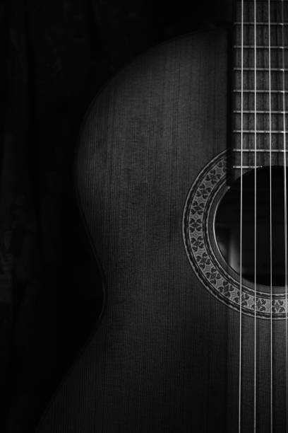 Musical concept. Classic guitar detail. close up. black and white photo. dark key. Spanish guitar, dark background, copy space. acoustic music photos stock pictures, royalty-free photos & images