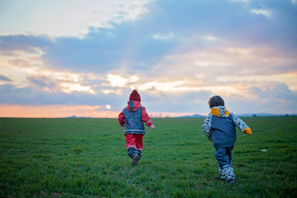 istock Two adorable children, boy brothers, watching beautiful splendid sunset 1366030659
