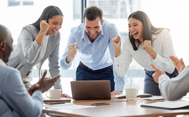 istock Shot of a group of businesspeople cheering while using a laptop in an office at work 1366032070
