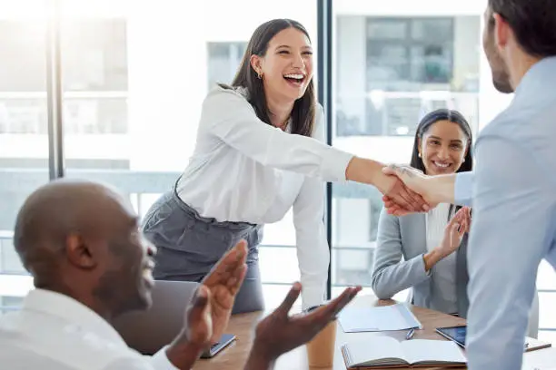 Photo of Shot of two businesspeople shaking hands in an office at work