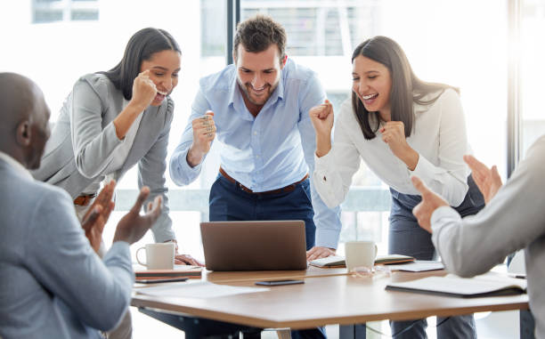 istock Shot of a group of businesspeople cheering while using a laptop in an office at work 1366032113