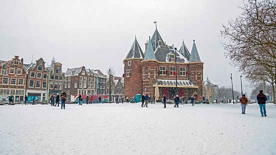 Amsterdam, Netherlands, 15 december 2020: Traditional snowy Waag building at the Nieuwmarkt in Amsterdam in the Netherlands in winter