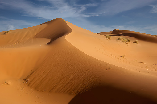 Fluffy clouds over the sand dunes in the Sahara desert