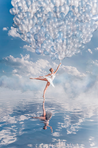 Beautiful ballerina in lake with balloons