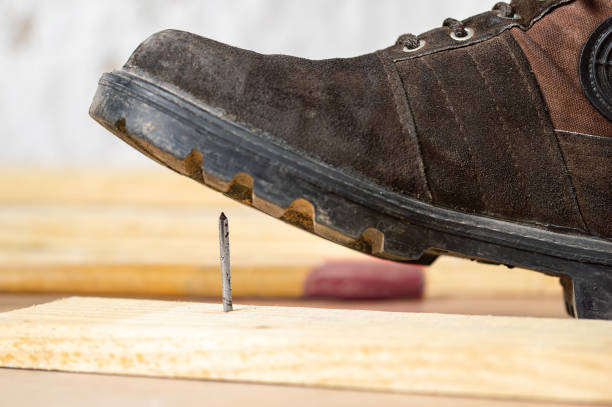 istock man's foot stepping over there nail inserted in wooden plank 1366038164