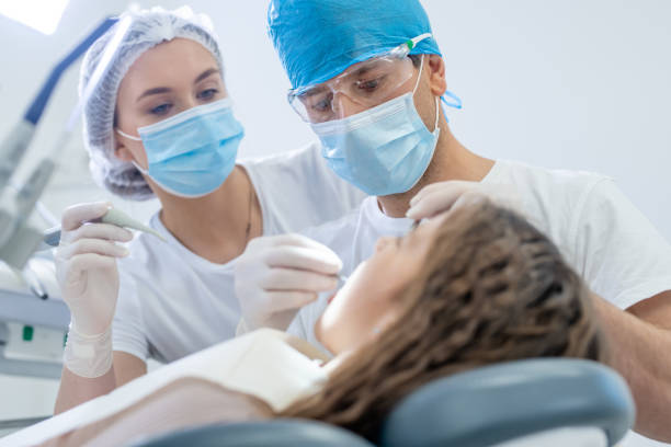 여성 환자의 치아를 검사하는 남성 치과 의사 - dentists chair chair dentist office stomatology 뉴스 사진 이미지