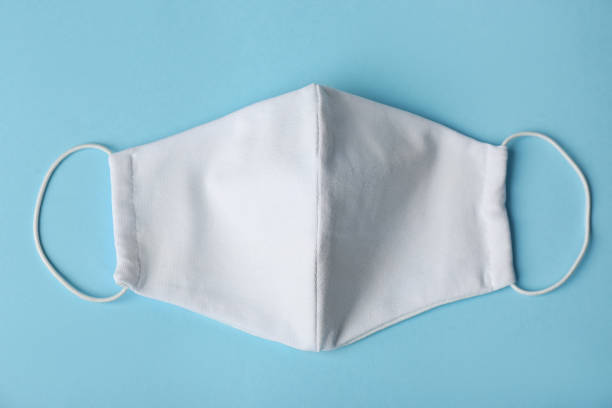 istock Homemade protective face mask on light blue background, top view 1366042426