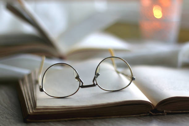istock Open Books, Reading Glasses and Lit Candle 1366042822