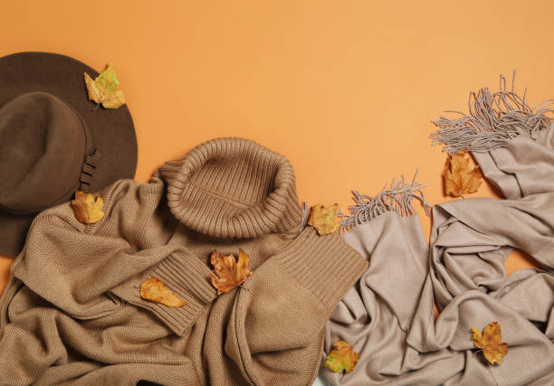 istock Flat lay composition with sweater and dry leaves on orange background, space for text. Autumn season 1366042926