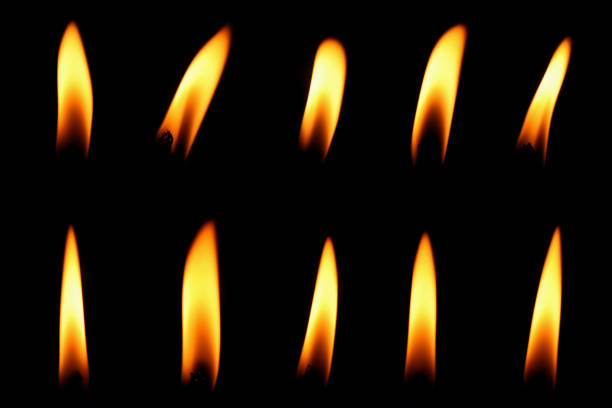 candle flame candle flame is burning at night in close range, yellow light isolated on black background. Flame stock pictures, royalty-free photos & images