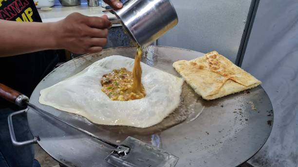 istock chef cooking and frying martabak in wok 1366044552