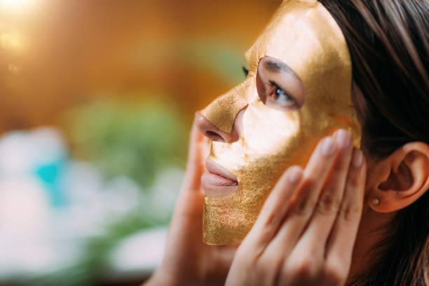 istock Woman with Gold Face Beauty Mask 1366045103