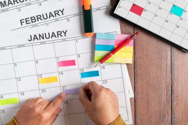 istock View from above of a person's hand using colored post it notes to write down the most important activities to do during the month. Calendar in Spanish. Concept plans and objectives, goal fulfillment 1366051044