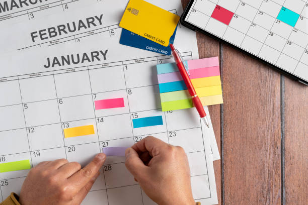 istock Top view of a person's hand using colored post it notes to write down the most important credit card payments and expenses to be made during the month. Concept of payment plans and debts. 1366051045