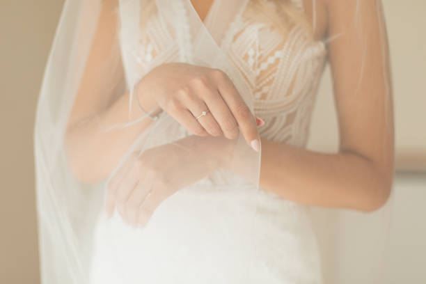 그녀의 결혼식 날을 준비하는 동안 흰색 웨딩 드레스와 신부 베일을 입고 인식 할 수없는 신부 손의 작물 사진 - bride caucasian wedding ceremony close up 뉴스 사진 이미지