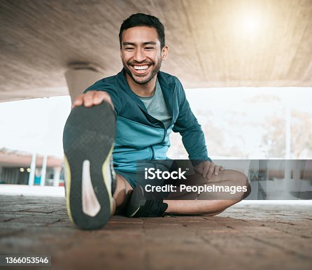 istock Shot of a young man stretching before a run 1366053546