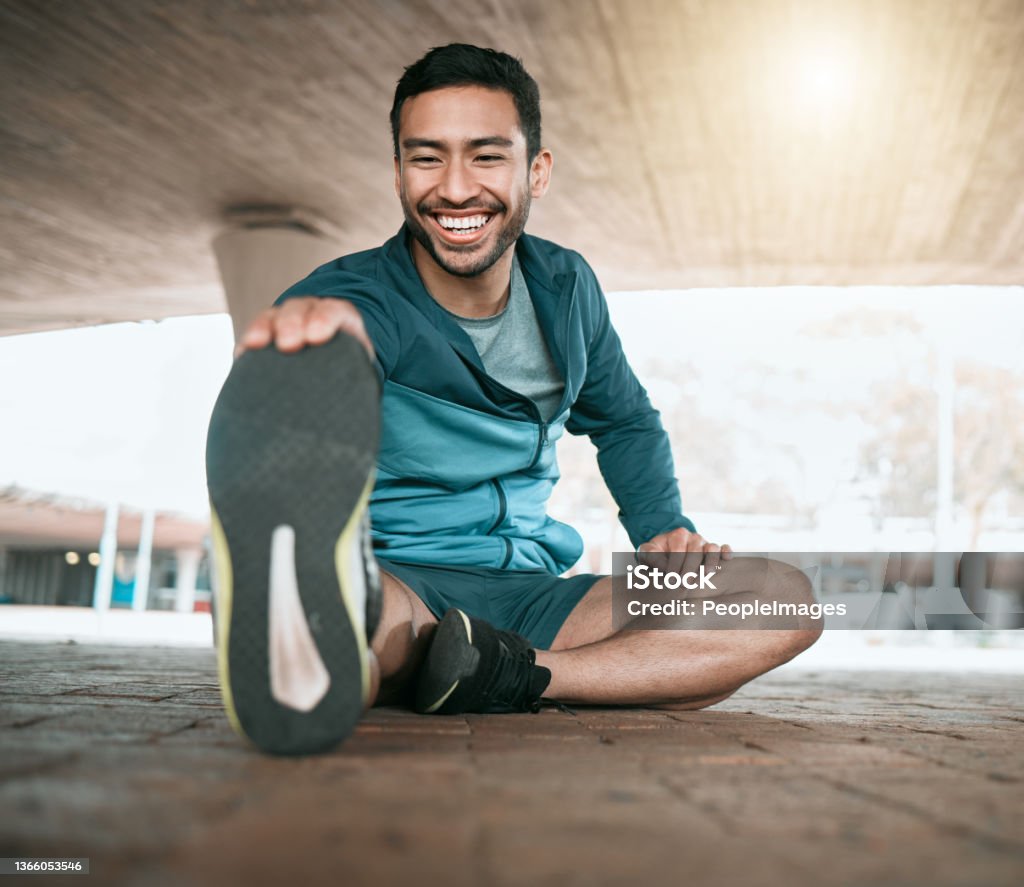 Shot of a young man stretching before a run Ready to move my body Exercising Stock Photo