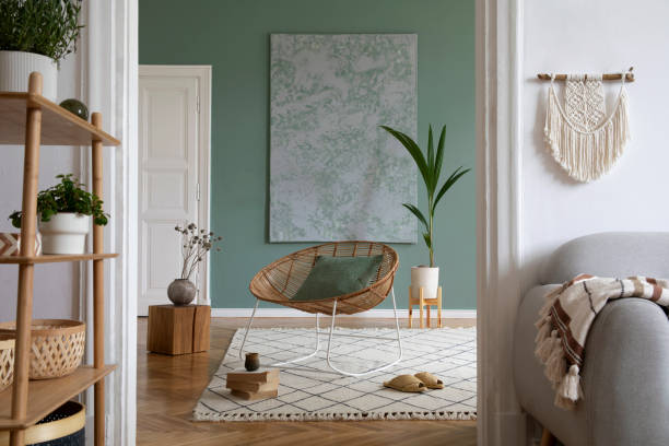 istock Creative living room interior design composition with crey scandi sofa, rattan armchair, plants, carpet and beautiful boho accessories. Eucalyptus walls and parquet floor. 1366055291