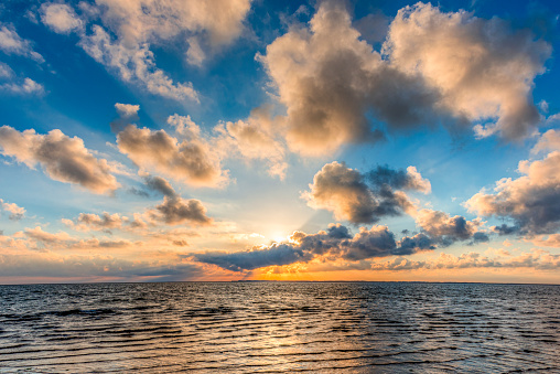 Sunset on the North Sea coast in the Wadden Sea with calm seas and clouds gathering