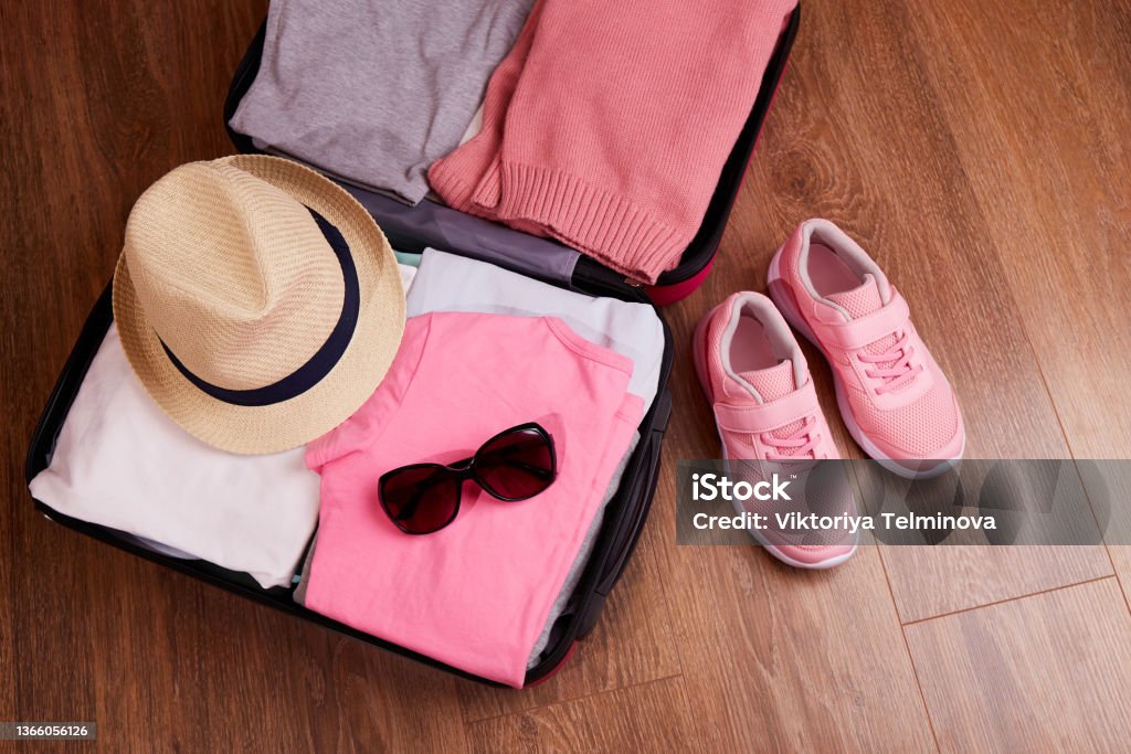 An open suitcase with women's clothing and accessories for the upcoming trip An open suitcase with women's clothing and accessories for the upcoming trip. Suitcase Stock Photo