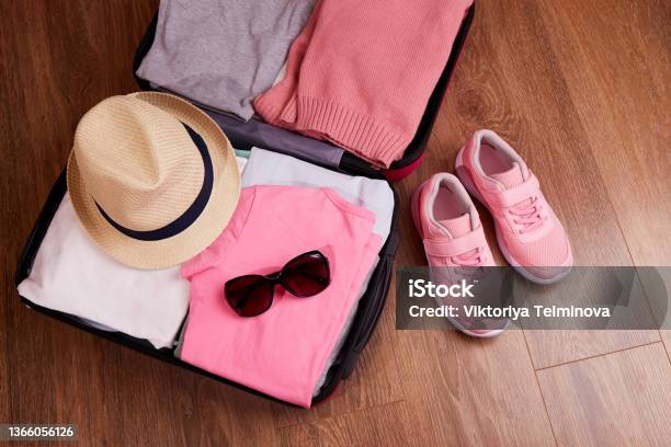 An Open Suitcase With Womens Clothing And Accessories For The Upcoming Trip Stock Photo - Download Image Now