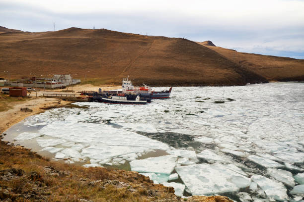 balsas de passageiros no píer na ilha de olkhon na primavera. o período de derretimento do gelo do lago baikal, blocos de gelo flutuam na água - ice floe - fotografias e filmes do acervo