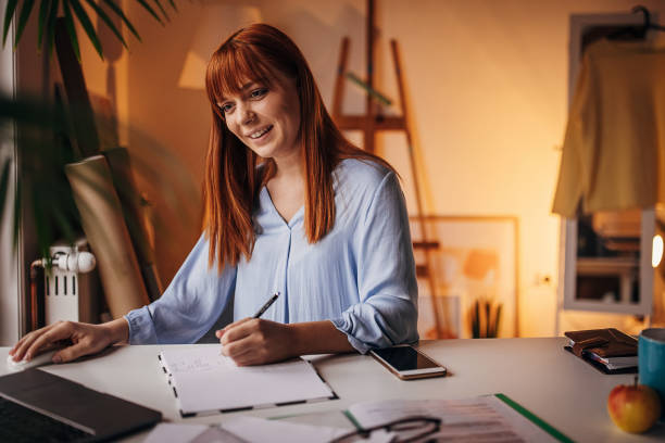 istock Redhead woman working in home office 1366056398