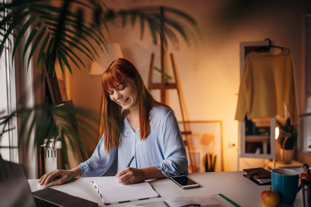 istock Redhead woman working in home office 1366056443