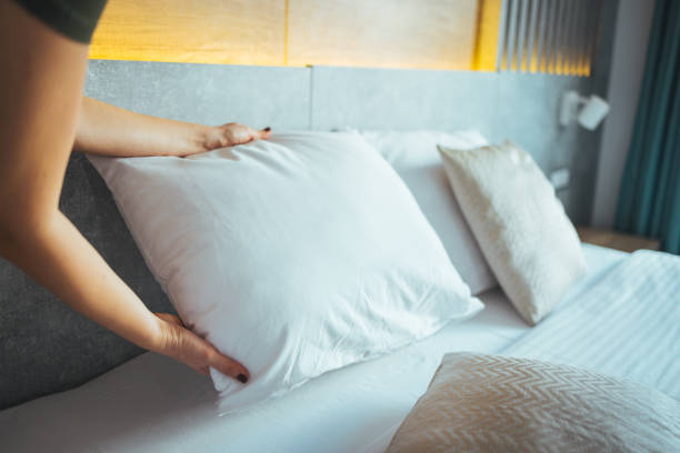 istock Female Hand set up white bed sheet in bedroom. 1366057750