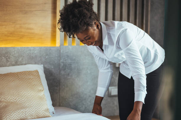 istock African maid making bed in hotel room. 1366058189
