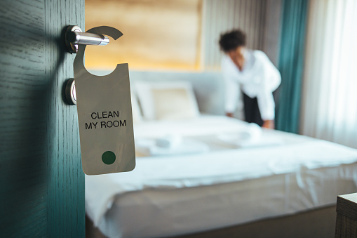 Please make up my room. Maid cleaning the room with please make up my room sign on the door. Opened door of hotel room in morning.Hotel, door open. Clean and elegant accommodation service.