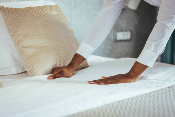 istock Maid working at a hotel making the bed and pillows. 1366061245