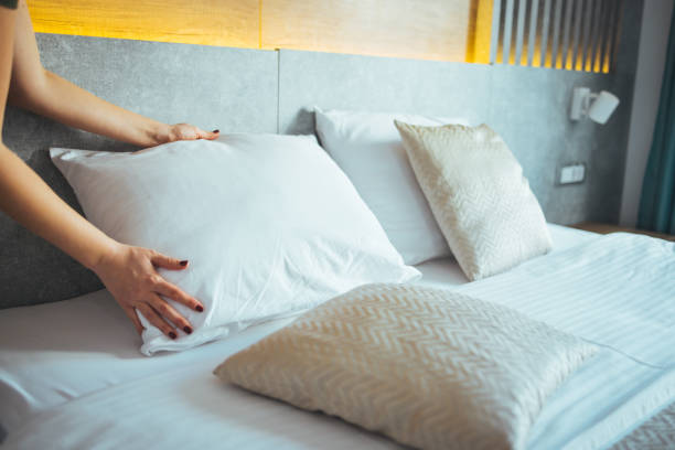 istock Female Hand set up white bed sheet in bedroom 1366061346