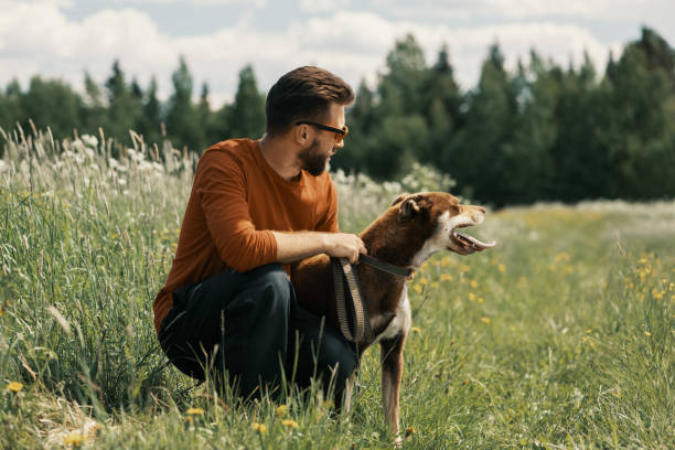 istock Man and happy dog looking away in rural. 1366061973