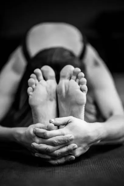 Photo of Concept of concentration, spirituality, training, development, self-discipline. Black and white photograph of a woman in an asana. Meditation, mental and physical healthy. Close-up