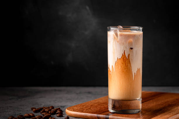 Ice coffee in a glass with cream poured over stock photo
