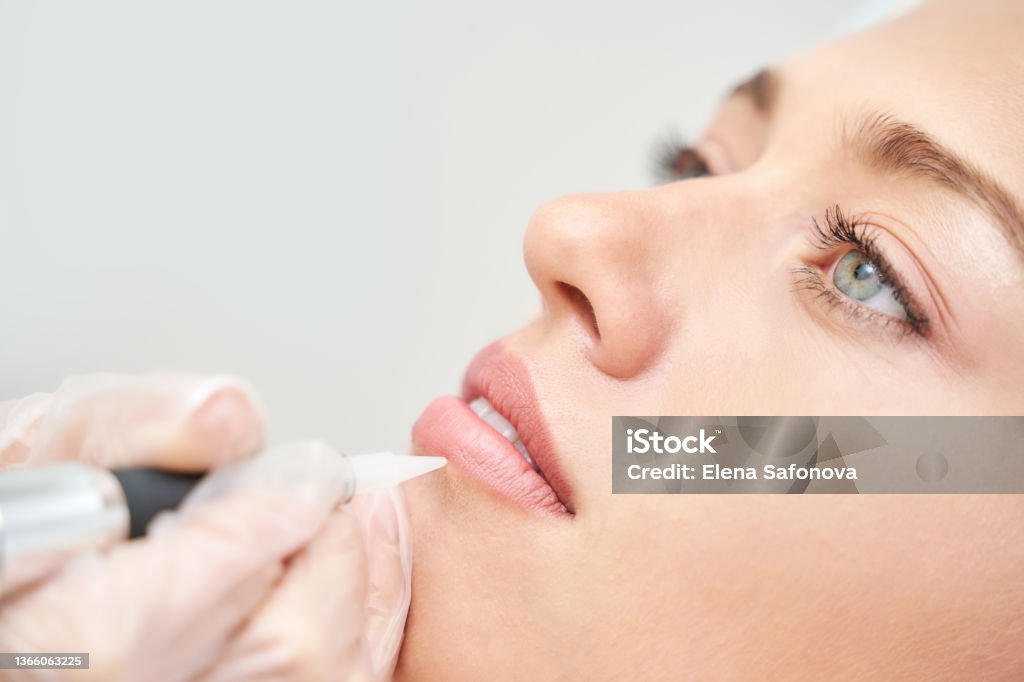 Permanent makeup. Beauty spa procedure. Beauty young woman. Lip tattoo Permanent makeup. Beauty spa procedure. Beauty young woman. Lip tattoo. Liner micropigmentation. Professional face microblading. Female cosmetology device. Permanent Make-Up Stock Photo
