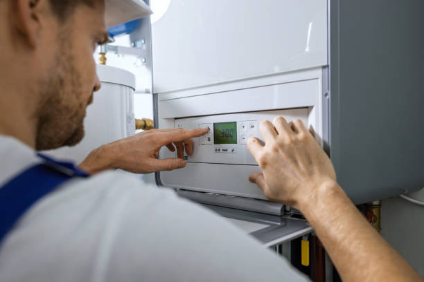 worker set up new central gas heating boiler for home stock photo