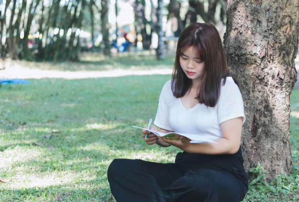 istock Young woman studying at the park 1366066691