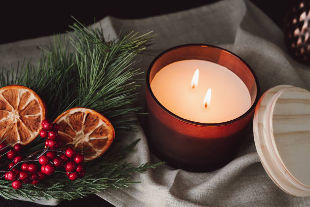 istock Lit Chocolate Brown Candle Against Dark Background with Dried Oranges and Cranberries 1366067227