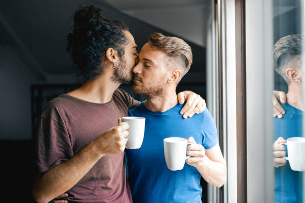 couple of gay men drinking coffee at home, morning ritual of same sex lovers, gay pride and marriage lifestyle - homosexual beautiful sensuality love imagens e fotografias de stock