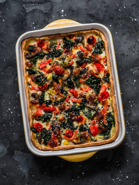 istock Snack pie with vegetables, fish, spinach and cheese on shortbread dough on a dark background, top view 1366067621