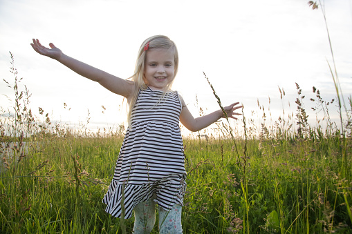 Candid portrait of happy toddler girl on a meadow