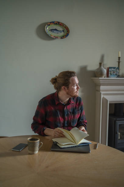 Young man works online, at living room table