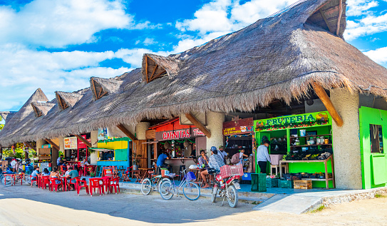 Holbox Mexico 22. December 2021 Colorful village on beautiful Holbox island with restaurant store vehicles people and mud in Quintana Roo Mexico.