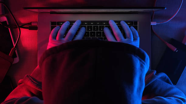 hacker trabalhando em laptop à noite - cracking the code - fotografias e filmes do acervo