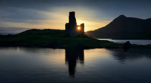 Panorama of Ardvreck Castle reflections on Loch Assynt in sunset light, Scotland